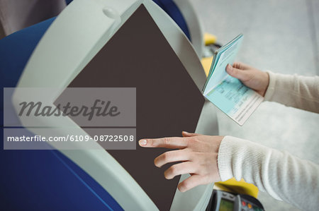 Traveller using self service check-in machine at airport