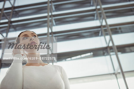 Woman talking on mobile phone in waiting area at airport terminal