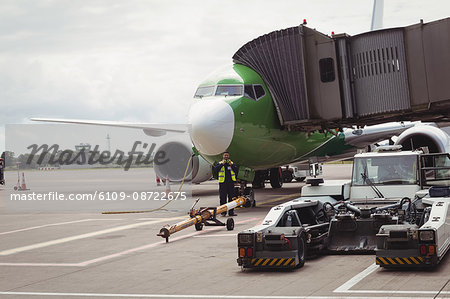 Airplane with loading bridge getting ready for departure at airport terminal