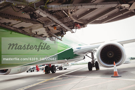 Airplane with loading bridge getting ready for departure at airport terminal