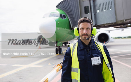 Portrait of airport ground crew standing on runway at airport terminal Portrait of airport ground crew standing on runway at airport terminal