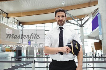 Portrait of pilot standing in airport terminal