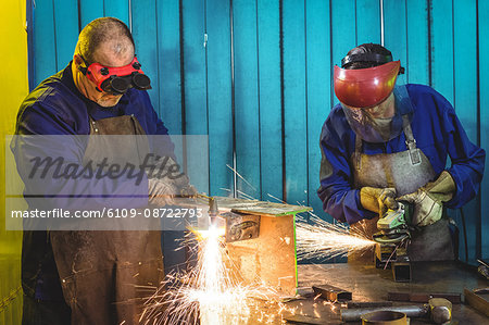 Male and female welders working together in workshop