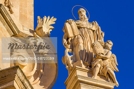 Ornate detail of mouldings and statue on the San Giuseppe Church against blue sky in Ragusa in Sicily, Italy