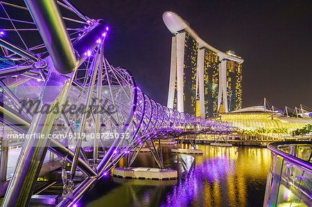 People strolling on the Helix Bridge towards the Marina Bay Sands and ArtScience Museum at night, Marina Bay, Singapore, Southeast Asia, Asia