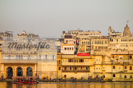 Old building facades, boat in foreground, City Palace side, Lake Pichola, Udaipur, Rajasthan, India, Asia