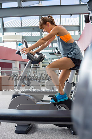 Young woman exercising on a machine in a fitness club