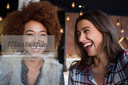Portrait of happy female friends having fun in cafe