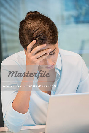 Stress businesswoman sitting in front of a laptop