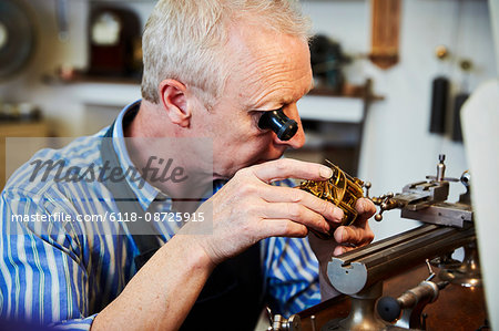 A clock maker busy in his workshop.