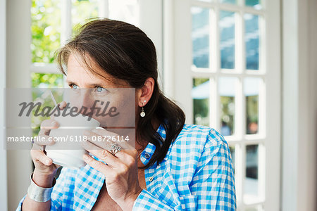 A woman having a cup of coffee.