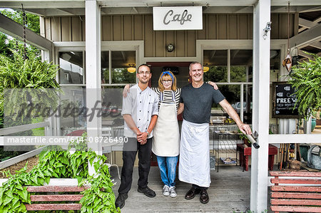 Cafe owner and partners posing in front of restaurant