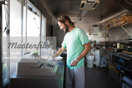 Man preparing food for customer in fast food trailer