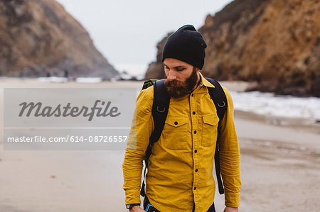 Hiker walking on beach, Big Sur, California, USA