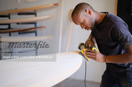 Craftsman making paddleboard in workshop