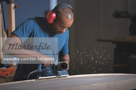 Craftsman making paddleboard in workshop