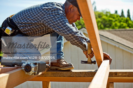 Builder taking measurements on a construction site.