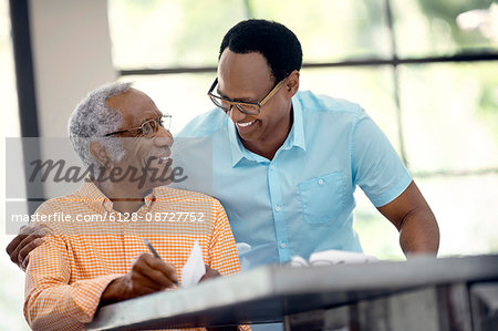 Father and son do taxes together. Father and son do taxes together.