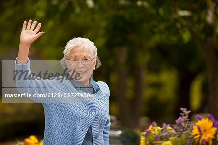Portrait of a smiling senior woman waving.