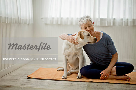 Portrait of a happy mature woman patting her pet dog. Portrait of a happy mature woman patting her pet dog.