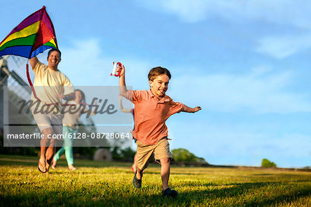 Little boy flying a kite with his parents.