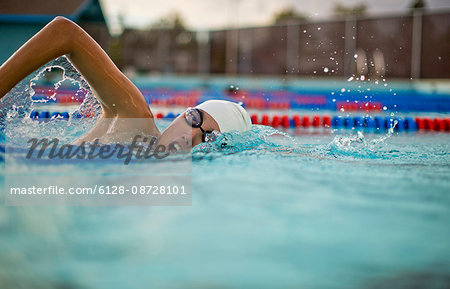 Young woman swimming the front crawl in a pool.