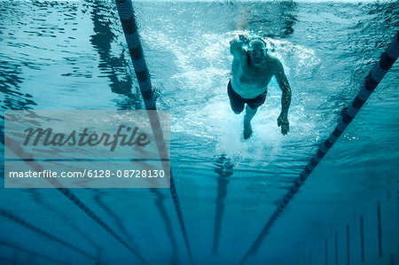 Mature man swimming laps at his local pool.