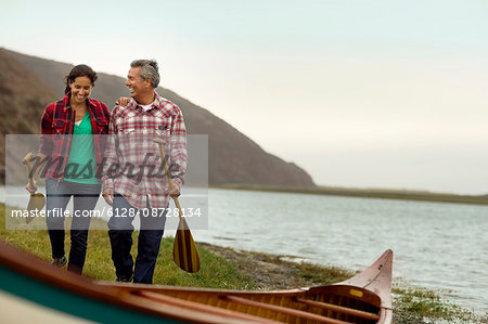 Mature couple walking towards their canoe.