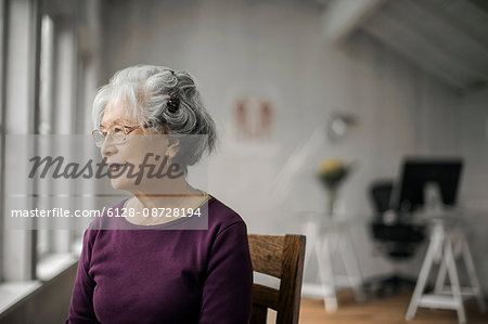 Portrait of a senior woman gazing pensively out a window.