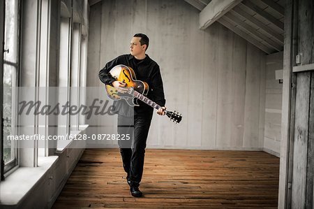 Teenage boy playing his electric guitar.