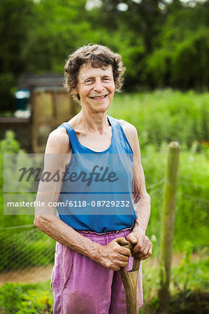 A woman holding a shovel on a farm.