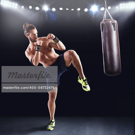 Man is training with the punching bag on gym