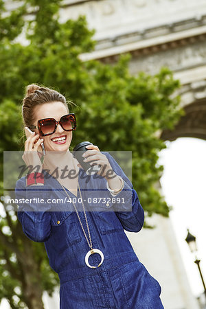 Get your bags ready for the Paris shopping. happy young fashion-monger with shopping bags speaking on a mobile phone while drinking coffee near Arc de Triomphe