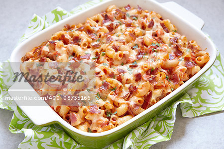Pasta casserole with bacon, ham, cheese and tomato sauce