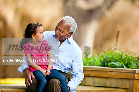 Young girl sitting on her grandfathers knee.