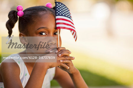 Portrait of a young girl holding an American flag.