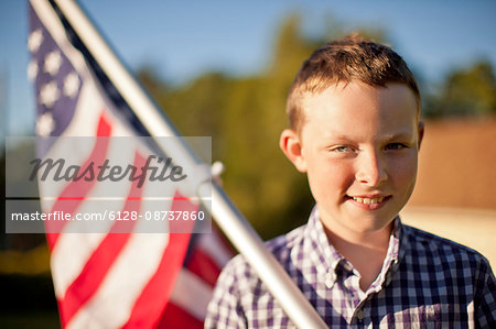 Portrait of a young boy holding an American flag.