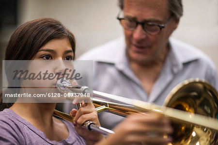 Teenage girl learning to play trombone.