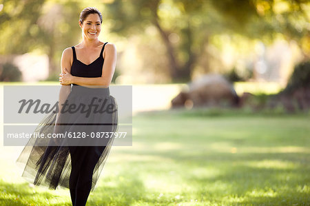 Mid adult woman smiling while standing in a park.