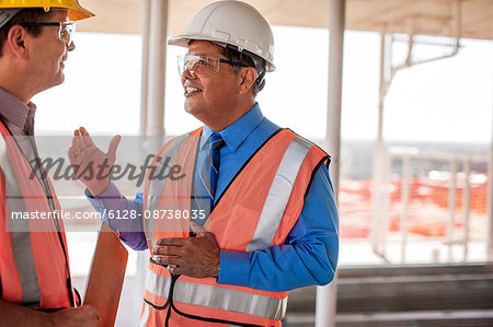 Two construction managers talking on building site.