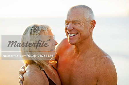 Senior couple embracing on a beach.