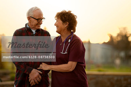 Smiling nurse comforting an elderly patient.