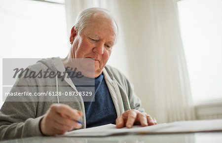 Senior man looking over important documents.