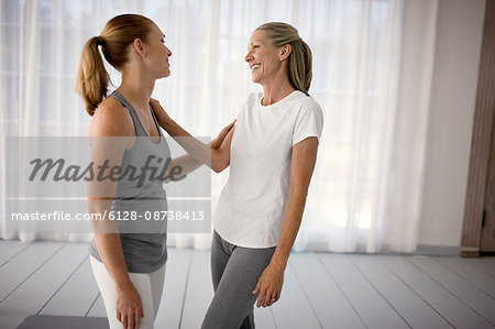 Smiling women talking after practicing yoga.