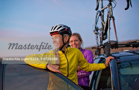 Smiling young women take one last look at the view of the sunset before they head home after a day of cycling in the countryside.