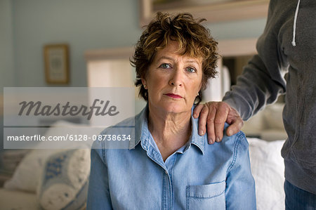 Portrait of a depressed mature woman sitting sadly on her bed.