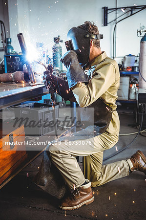 Welder welding a metal in workshop