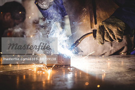 Welder welding a metal in workshop