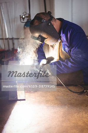 Welder welding a metal in workshop