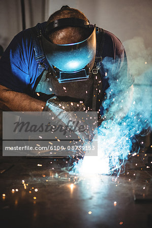 Welder welding a metal in workshop